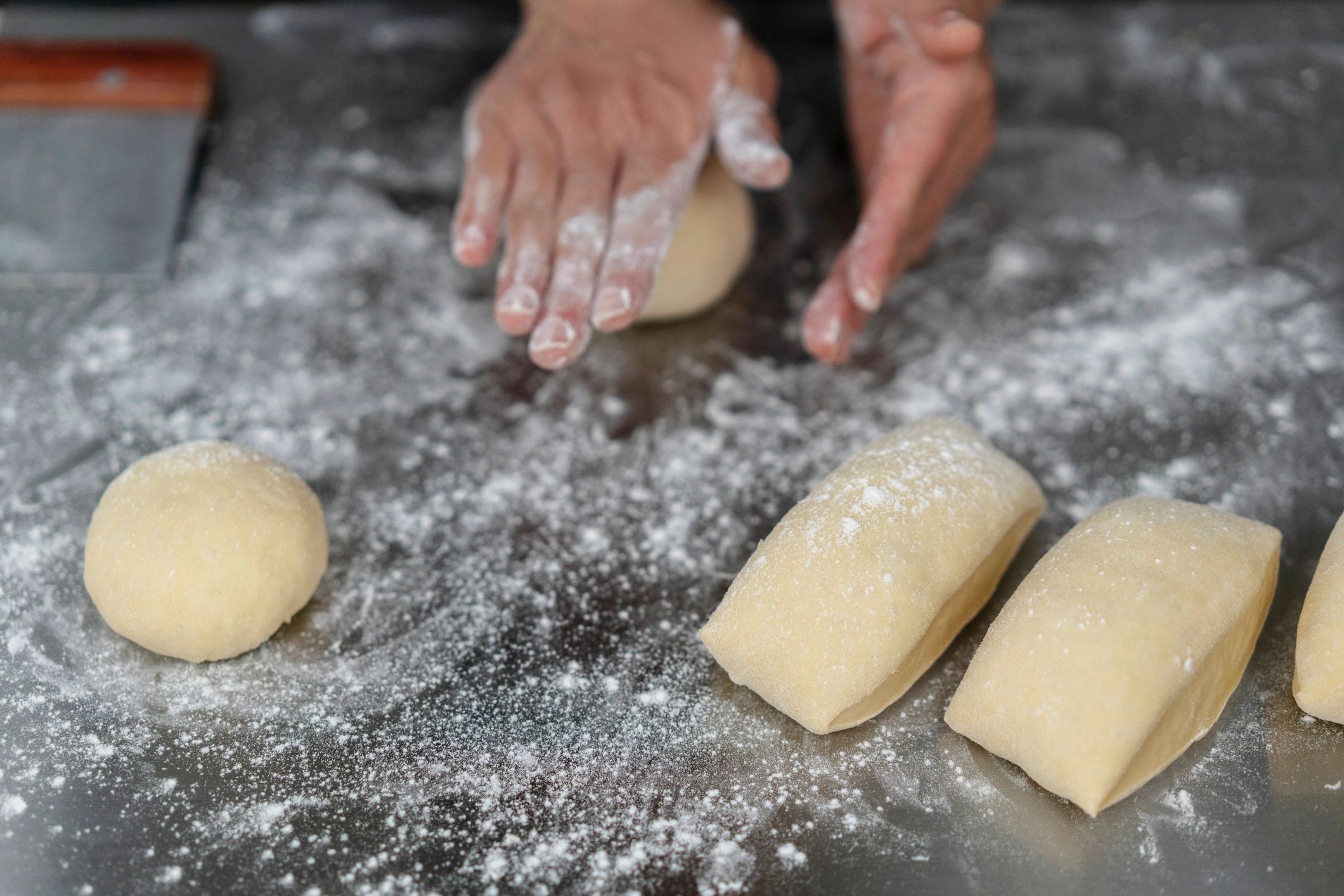 Hands kneading and shaping wholegrain bread dough