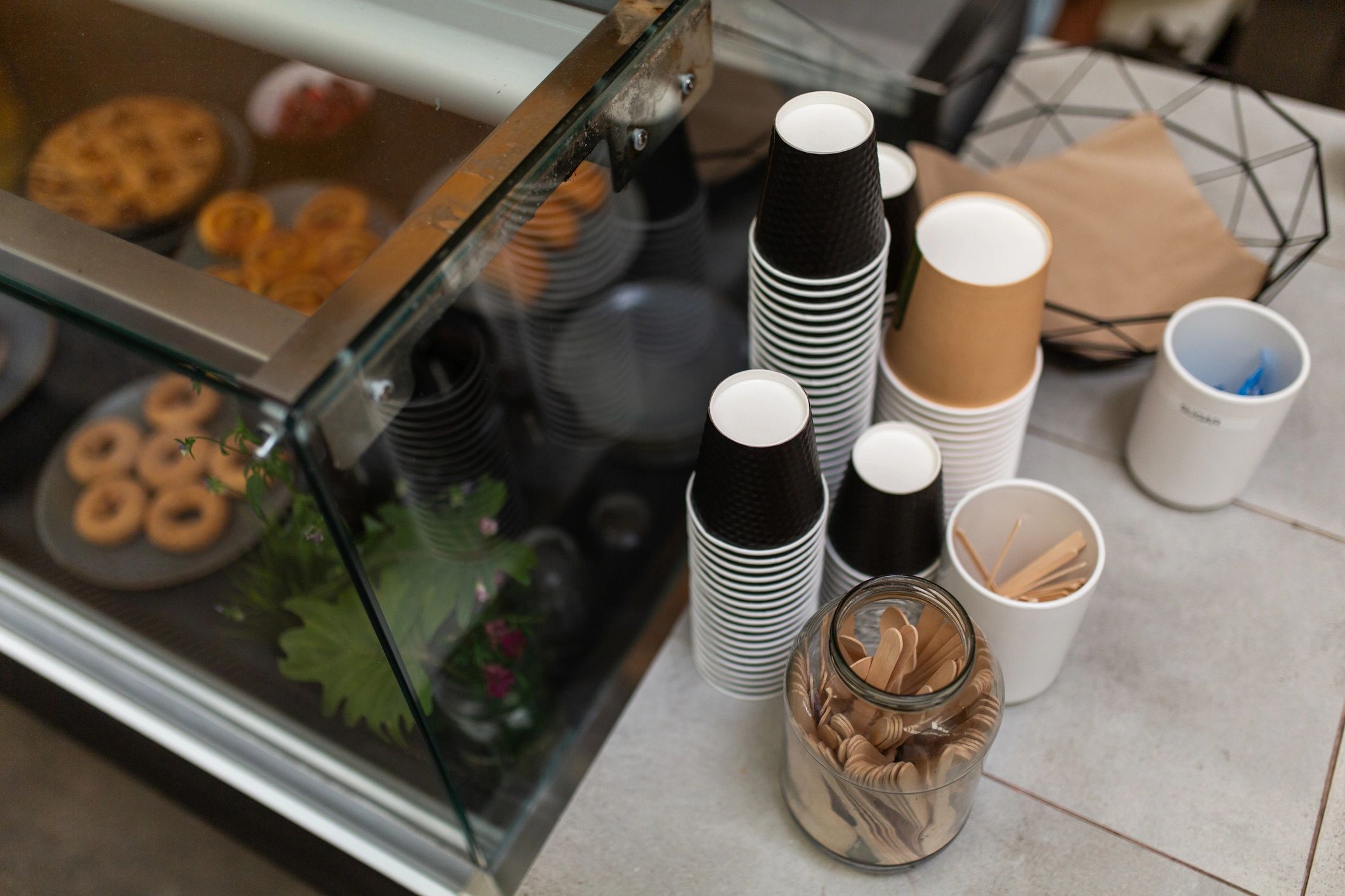 Cafe counter with takeaway cups near a display cabinet