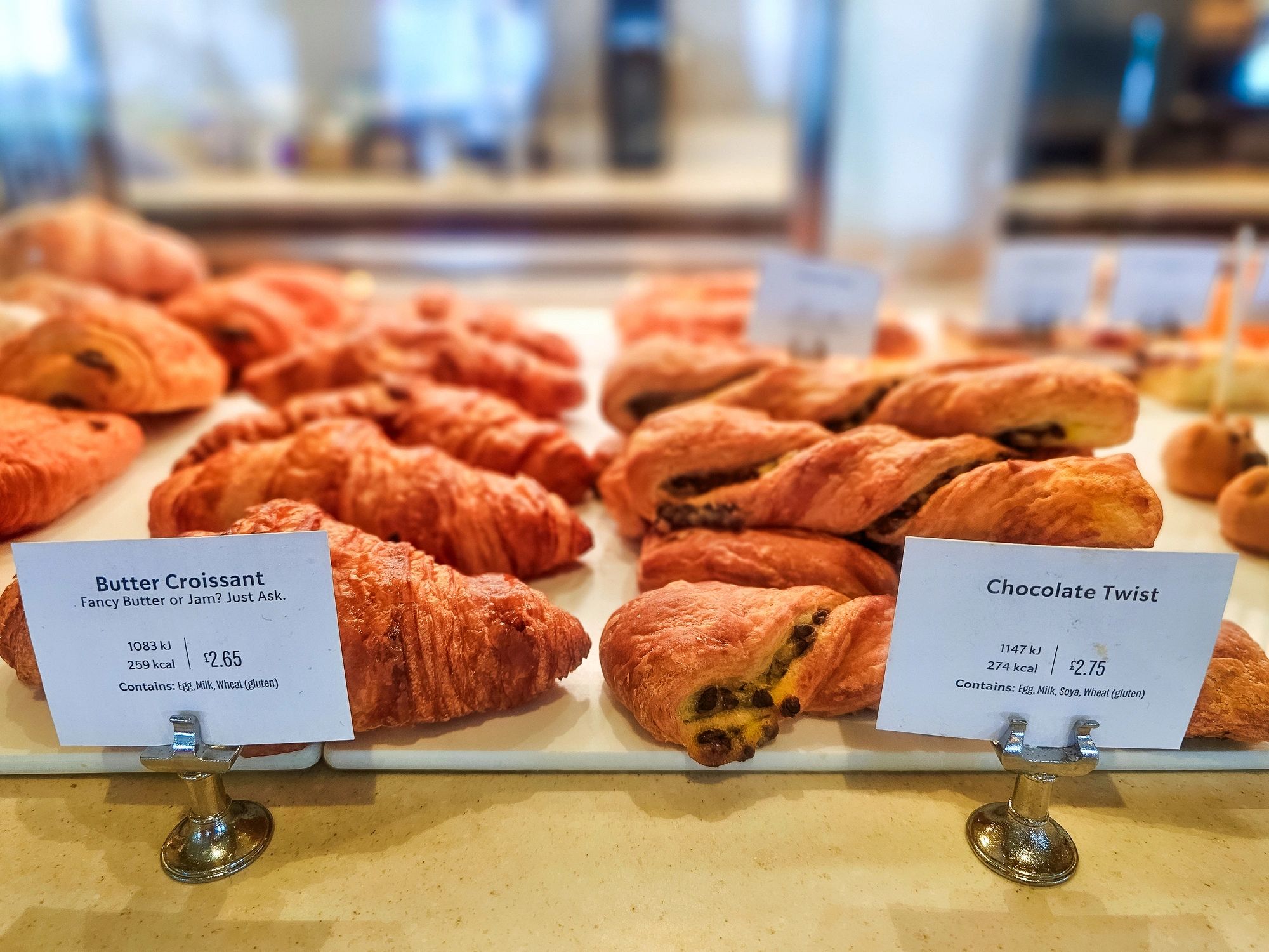 Almond croissants and pain au chocolat in a bakery display